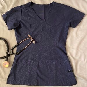 Jockey women’s scrub top. Navy blue with animal pattern detailing, size XXS.